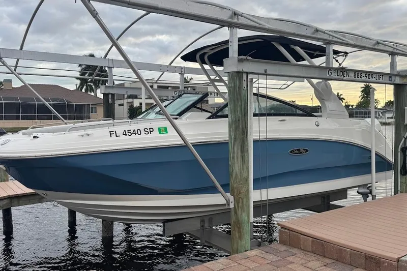 Slide: The Image of 2020 Sea Ray SDX 250 Outboard boat on calm water, near waterfront homes. - 3