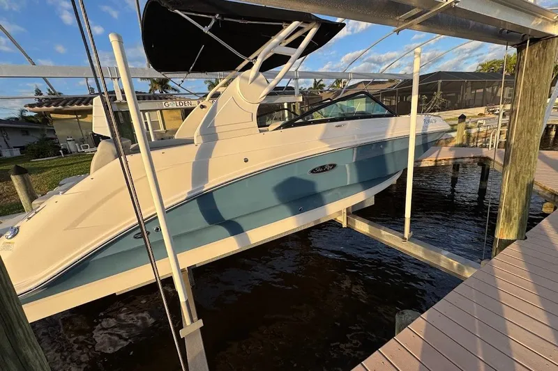 Slide: The Image of 2020 Sea Ray SDX 250 Outboard boat docked, featuring sleek design and blue hull. - 44