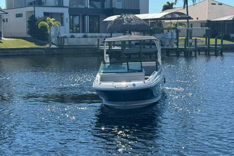 Slide: The Image of 2020 Sea Ray SDX 250 Outboard boat on a sunny waterfront near modern homes. - 47