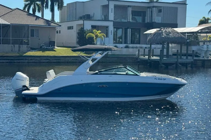 Slide: The Image of 2020 Sea Ray SDX 250 Outboard boat on a sunny waterfront, near modern homes. - 48