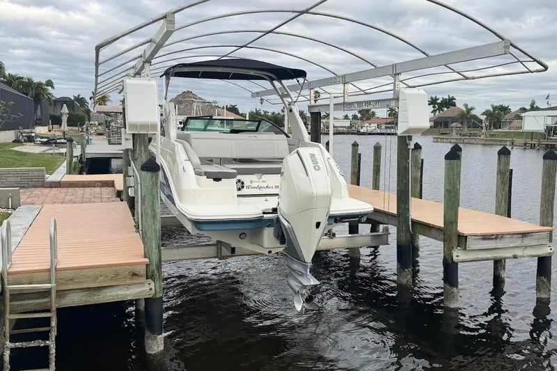 Slide: The Image of 2020 Sea Ray SDX 250 Outboard cruising on a sunny waterfront near modern homes. - 5