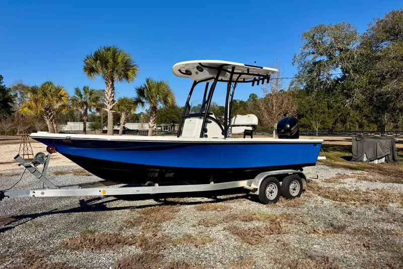 The Image of 2018 Sea Pro 208 Bay boat on trailer, parked outdoors with palm trees in background. - 1