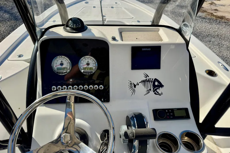 Slide: The Image of 2018 Sea Pro 208 Bay boat dashboard with steering wheel, gauges, and fish skeleton decal. - 9