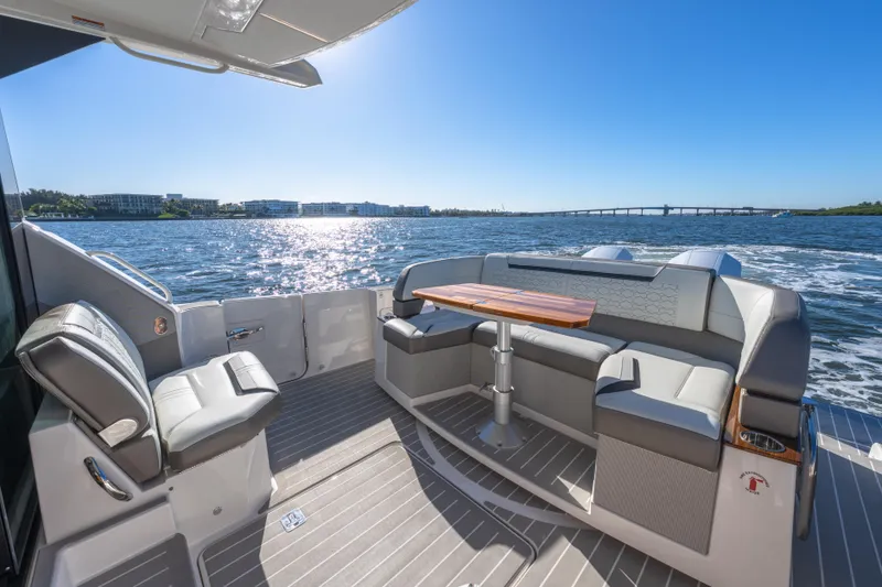 Slide: The Image of 2025 Tiara Yachts 43 LE luxury yacht deck with seating and table, cruising on sunny waters. - 10