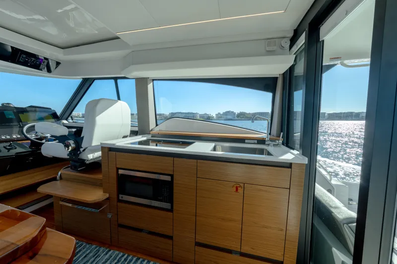 Slide: The Image of Interior of 2025 Tiara Yachts 43 LE, featuring helm and kitchenette with ocean view. - 15