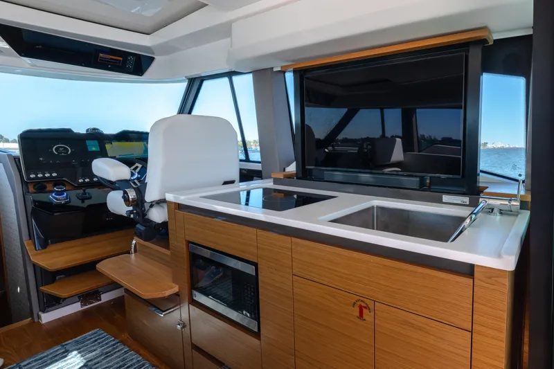 Slide: The Image of Interior of 2025 Tiara Yachts 43 LE, featuring helm and kitchenette with modern amenities. - 16