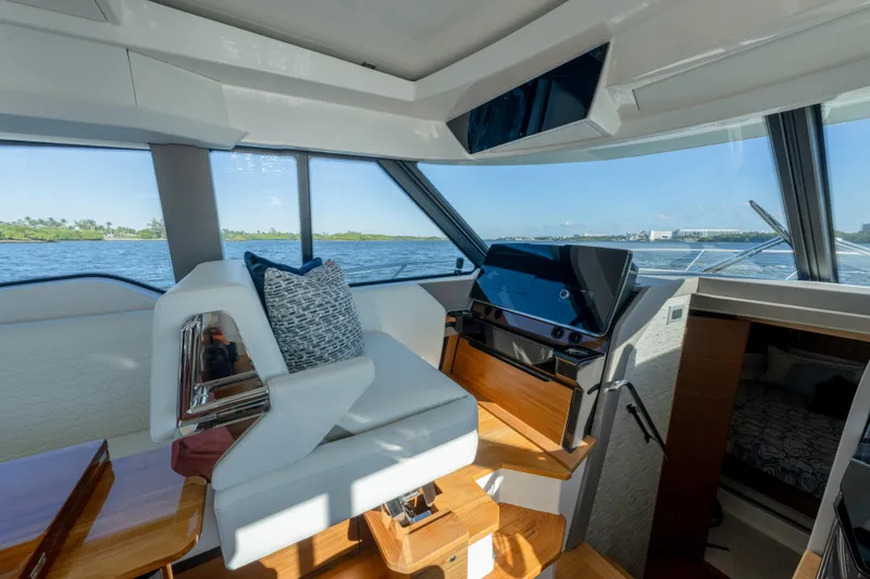 Slide: The Image of Interior of 2025 Tiara Yachts 43 LE, featuring helm station and scenic water view. - 22