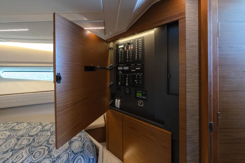 Slide: The Image of 2025 Tiara Yachts 43 LE interior with open electrical panel and stylish wood finish. - 35