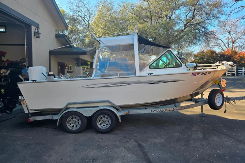 The Image of 2021 Alumaweld Intruder Outboard 20 boat on trailer, parked near a house. - 1