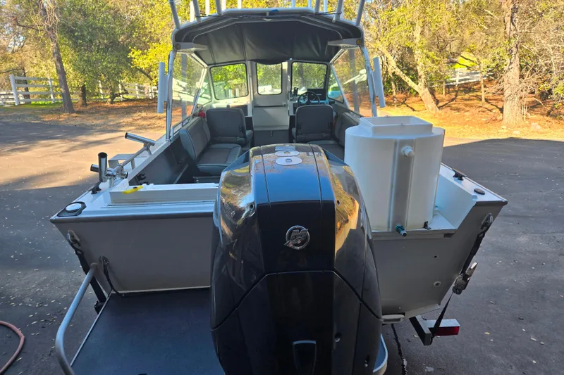 Slide: The Image of 2021 Alumaweld Intruder Outboard 20 boat with powerful engine, parked outdoors. - 5
