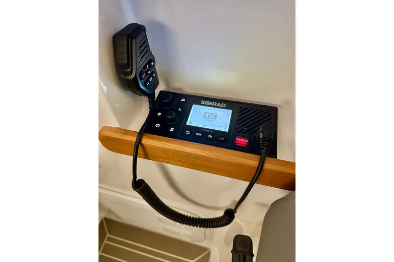 Slide: The Image of Simrad marine radio on 2023 Nimbus Weekender 9 boat, featuring a wooden handle. - 11