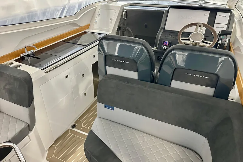 Slide: The Image of 2023 Nimbus Weekender 9 interior with modern helm, seating, and kitchenette. - 5