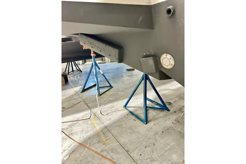 Slide: The Image of 2023 Nimbus Weekender 9 boat hull on blue stands in a workshop. - 54