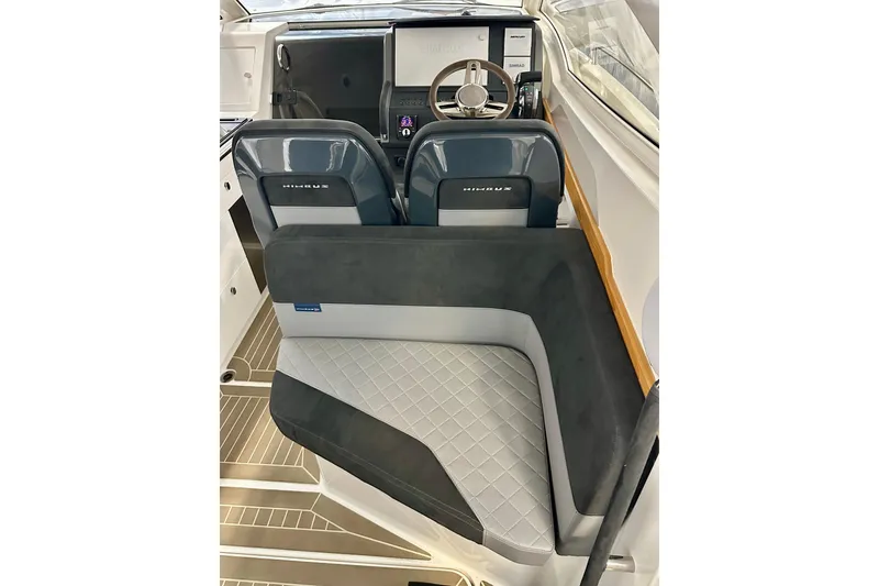 Slide: The Image of Interior of 2023 Nimbus Weekender 9 boat with modern seating and steering wheel. - 6