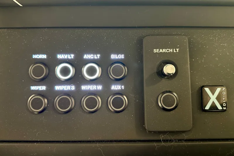 Slide: The Image of Control panel of 2023 Nimbus Weekender 9 boat with illuminated buttons and switches. - 13