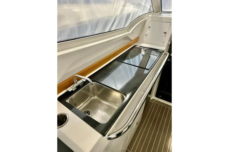 Slide: The Image of 2023 Nimbus Weekender 9 boat kitchen with sleek sink and stove setup. - 18