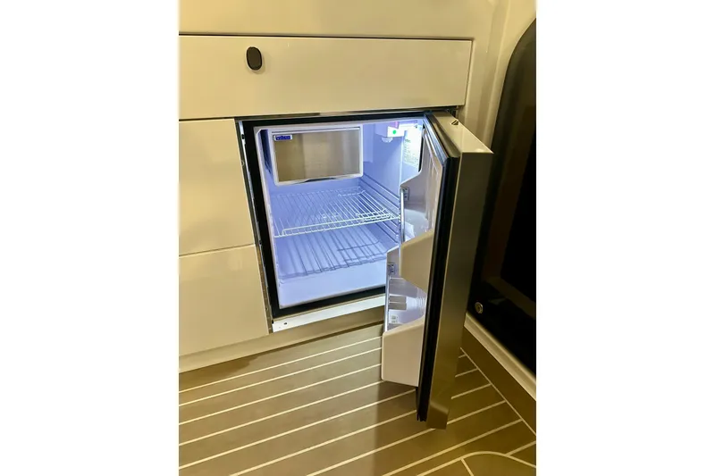 Slide: The Image of Open refrigerator inside 2023 Nimbus Weekender 9 boat, showcasing interior shelves. - 20