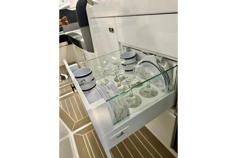 Slide: The Image of Drawer with glassware and dishes in 2023 Nimbus Weekender 9 boat interior. - 22
