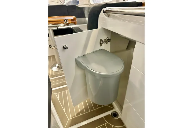 Slide: The Image of 2023 Nimbus Weekender 9 boat interior with compact toilet in open cabinet. - 24