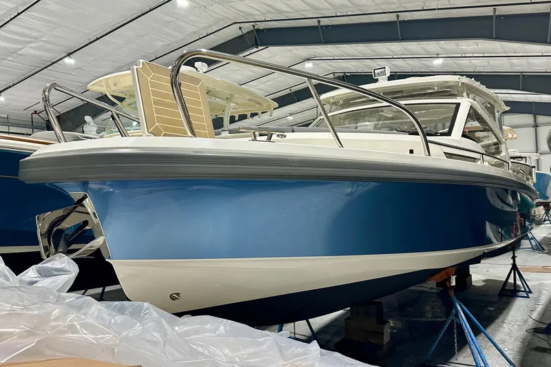 Slide: The Image of 2023 Nimbus Weekender 9 boat in a showroom, featuring a sleek blue and white design. - 3