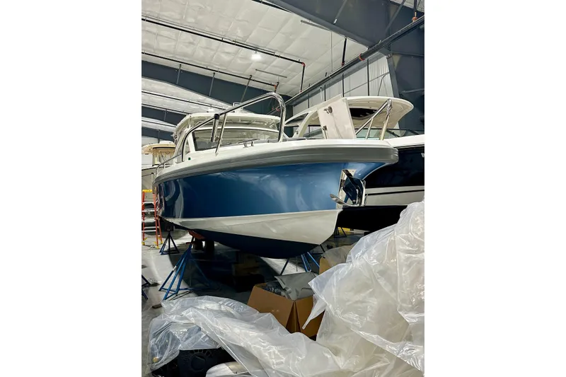 Slide: The Image of 2023 Nimbus Weekender 9 boat in a storage facility, blue and white hull. - 4