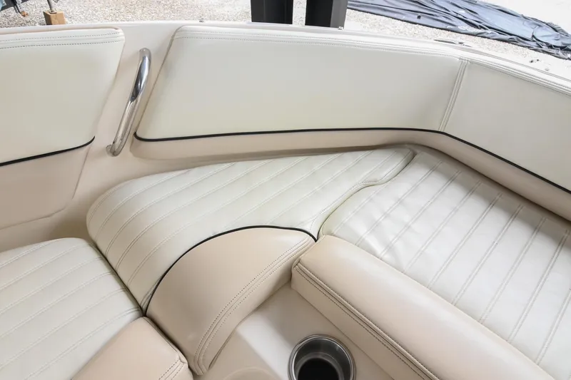 Slide: The Image of Luxurious seating in a 2007 Bryant 270 boat, featuring cream upholstery and stainless steel accents. - 14