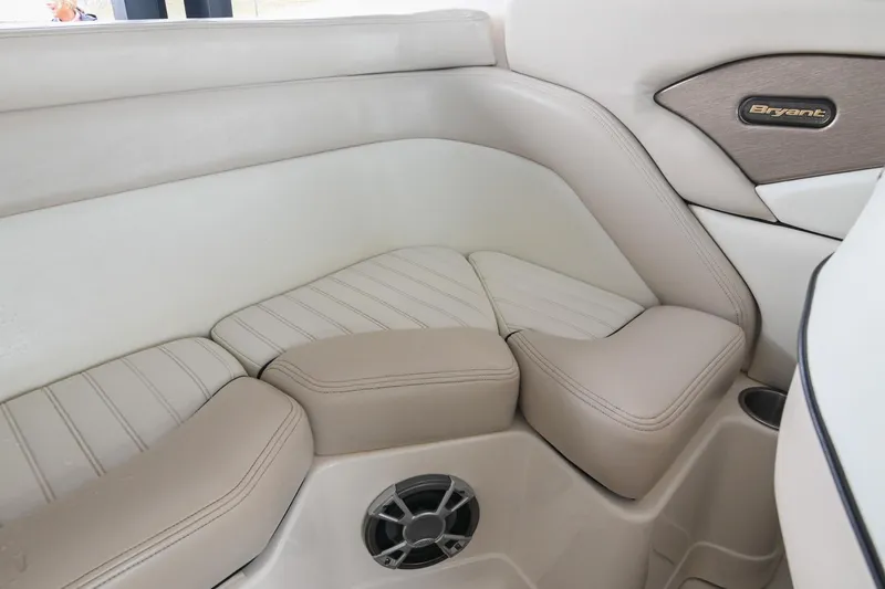 Slide: The Image of Interior seating of a 2007 Bryant 270 boat, featuring beige upholstery and speaker. - 17