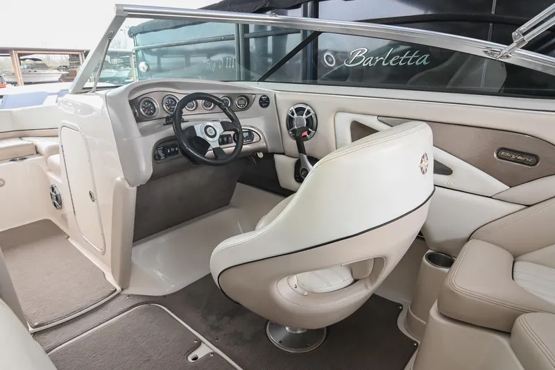 Slide: The Image of Interior of a 2007 Bryant 270 boat, featuring a sleek steering console and comfortable seating. - 34