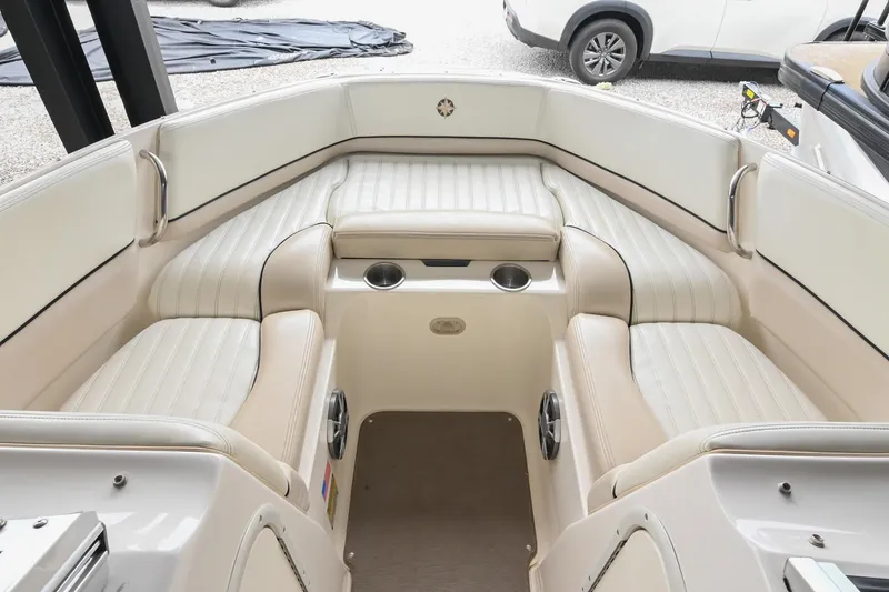 Slide: The Image of 2007 Bryant 270 boat interior with white cushioned seating and cup holders. - 38