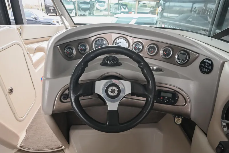 Slide: The Image of Steering wheel and dashboard of a 2007 Bryant 270 boat, featuring multiple gauges. - 4