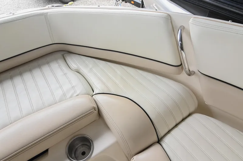 Slide: The Image of Interior seating of a 2007 Bryant 270 boat with white upholstery and cup holder. - 43
