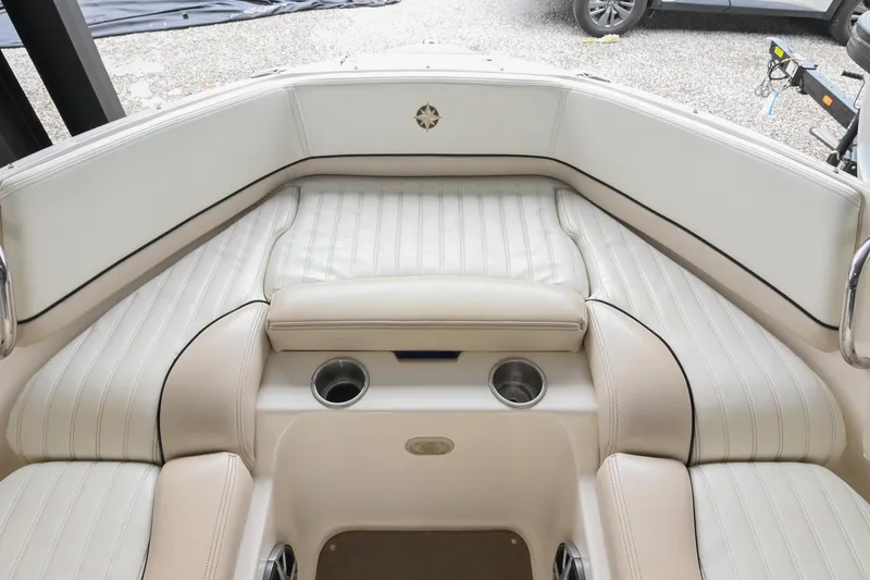 Slide: The Image of 2007 Bryant 270 boat interior with white cushioned seating and cup holders. - 44