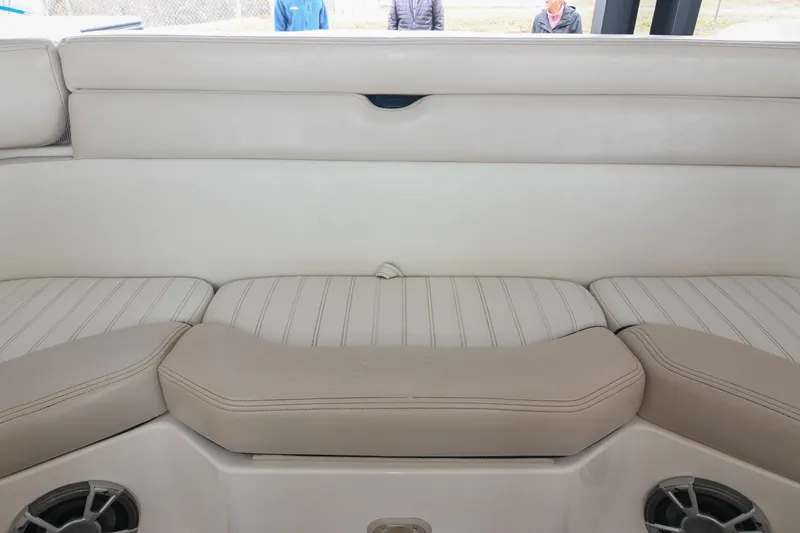 Slide: The Image of Interior seating of a 2007 Bryant 270 boat, featuring beige upholstery and built-in speakers. - 45
