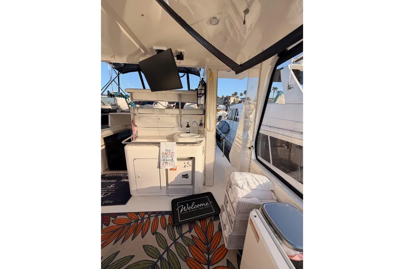 Slide: The Image of 1998 Sea Ray 420 Aft Cabin interior with kitchenette, TV, and welcome mat. - 14
