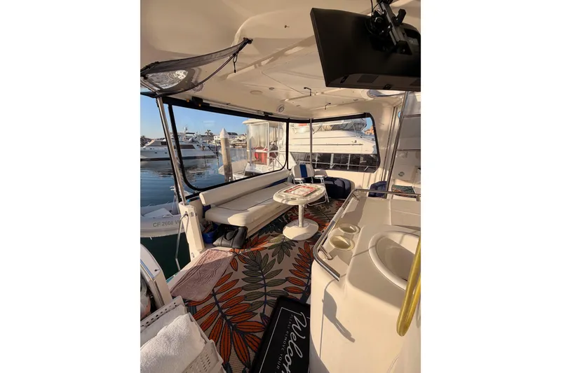 Slide: The Image of 1998 Sea Ray 420 Aft Cabin interior with seating, table, and marina view. - 20