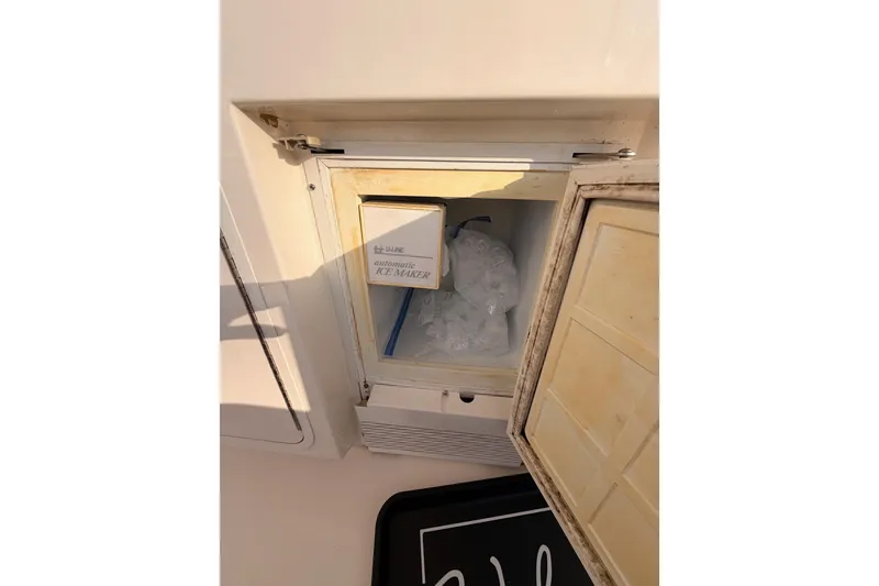 Slide: The Image of 1998 Sea Ray 420 Aft Cabin ice maker with open door, showing ice inside. - 23
