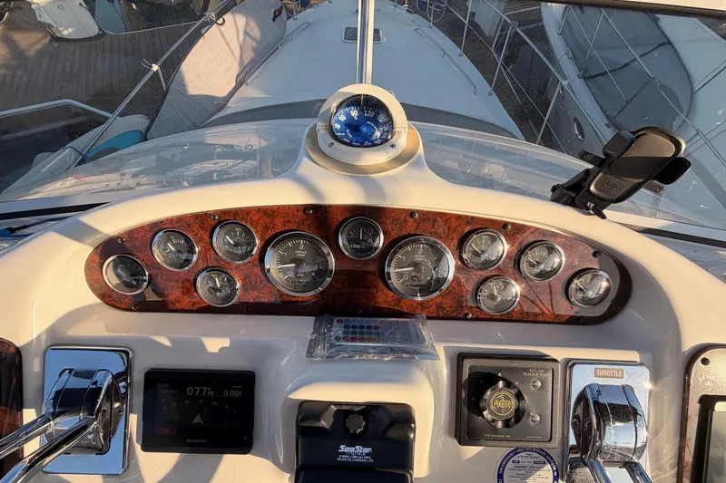 Slide: The Image of Control panel of a 1998 Sea Ray 420 Aft Cabin yacht with gauges and compass. - 34