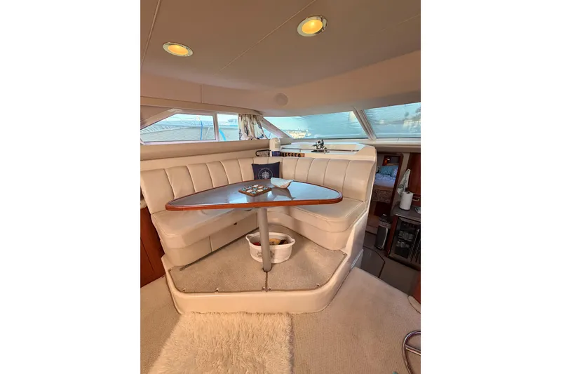 Slide: The Image of 1998 Sea Ray 420 Aft Cabin interior with cozy dining area and panoramic windows. - 48