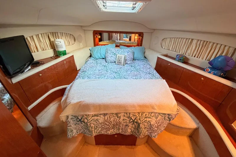 Slide: The Image of Luxurious 1998 Sea Ray 420 Aft Cabin bedroom with cozy bedding and elegant wood cabinetry. - 63