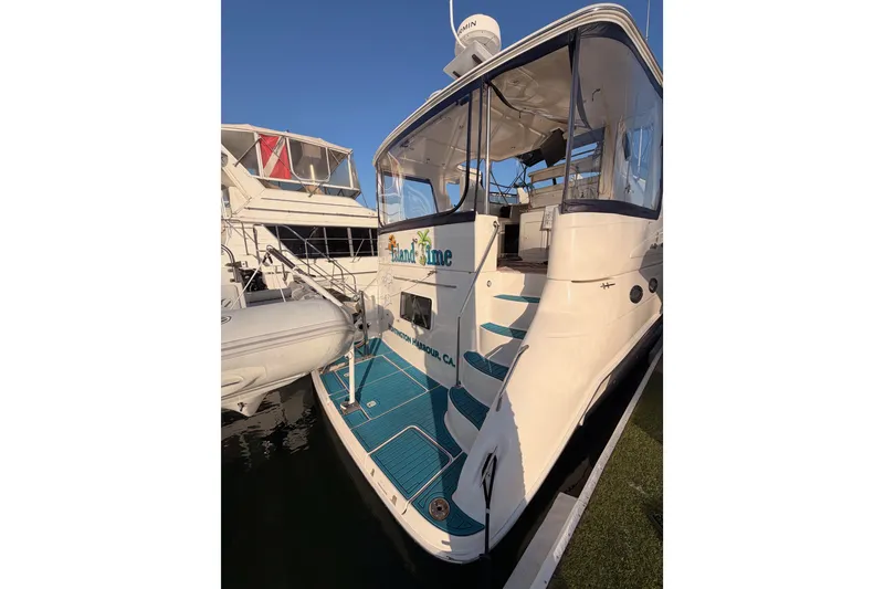 Slide: The Image of 1998 Sea Ray 420 Aft Cabin yacht docked, featuring blue deck and enclosed cabin. - 7