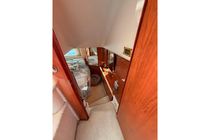 Slide: The Image of Interior view of 1998 Sea Ray 420 Aft Cabin, featuring cozy bedroom and wooden finishes. - 72