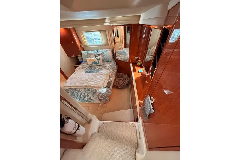 Slide: The Image of Luxurious 1998 Sea Ray 420 Aft Cabin interior with cozy bed and elegant wood finishes. - 73