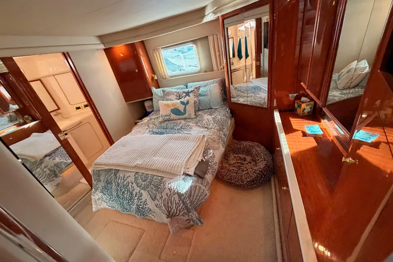 Slide: The Image of Luxurious 1998 Sea Ray 420 Aft Cabin bedroom with elegant wood finishes and cozy bedding. - 74