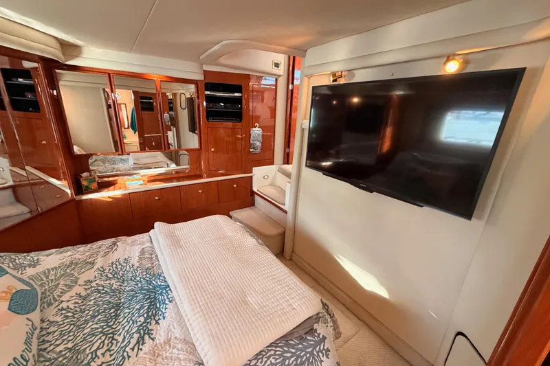 Slide: The Image of Luxurious 1998 Sea Ray 420 Aft Cabin interior with TV and elegant wood cabinetry. - 82