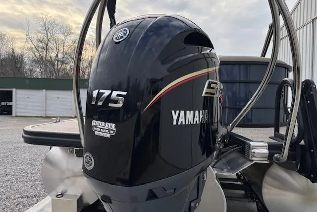 Slide: The Image of 2025 Bennington 23 SXPD with Yamaha 175 outboard motor, parked outdoors. - 6