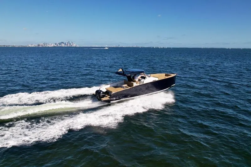 Slide: The Image of 2023 Tesoro T38 boat cruising on open water with city skyline in background. - 10
