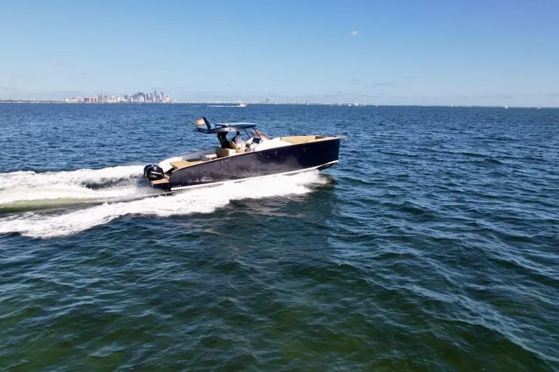 Slide: The Image of 2023 Tesoro T38 boat cruising on open water with city skyline in background. - 11
