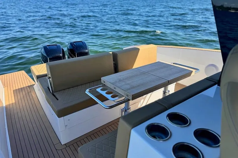 Slide: The Image of 2023 Tesoro T38 boat interior with seating, table, and dual engines on the water. - 21