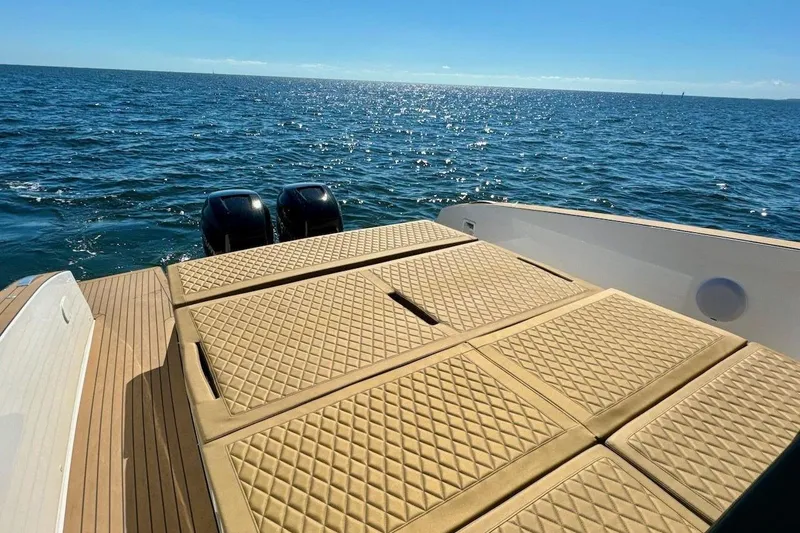 Slide: The Image of Luxury Tesoro T38 yacht deck with quilted seating, overlooking serene ocean waters, 2023 model. - 24