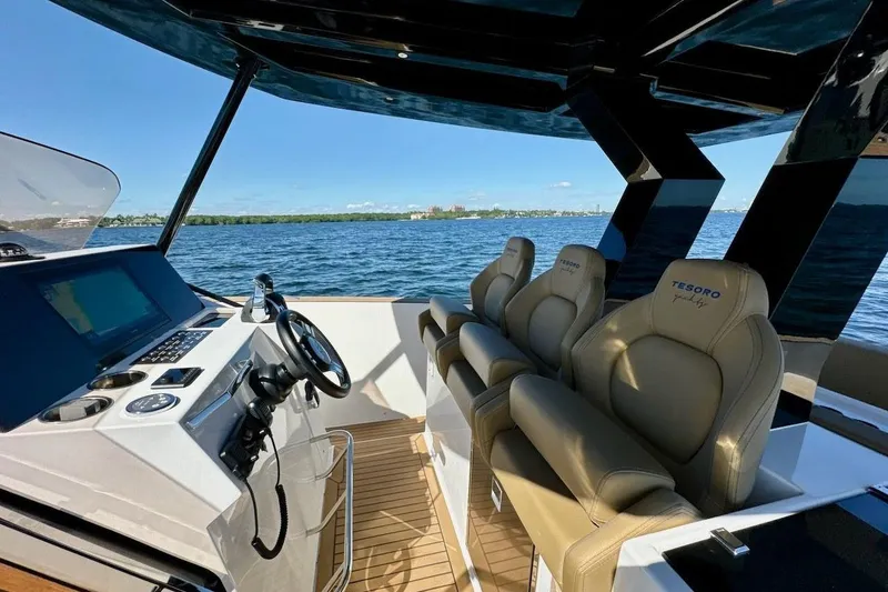 Slide: The Image of 2023 Tesoro T38 yacht interior with luxurious seating and modern dashboard on open water. - 36